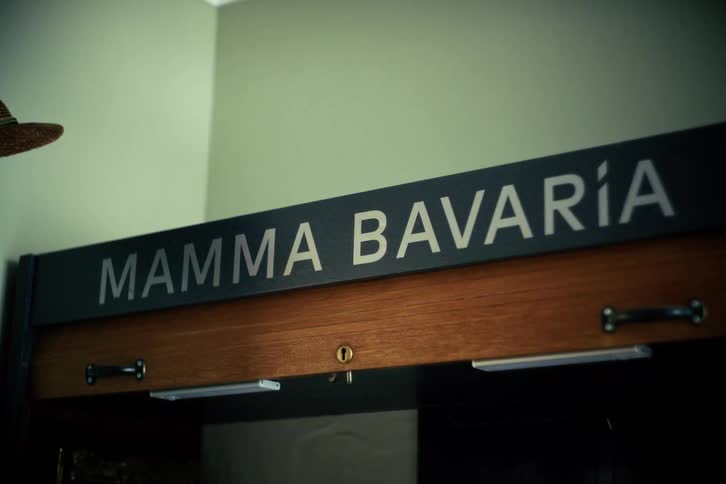 A static close-up shot of a sign that reads 'Mamma Bavaría' on a wooden surface
