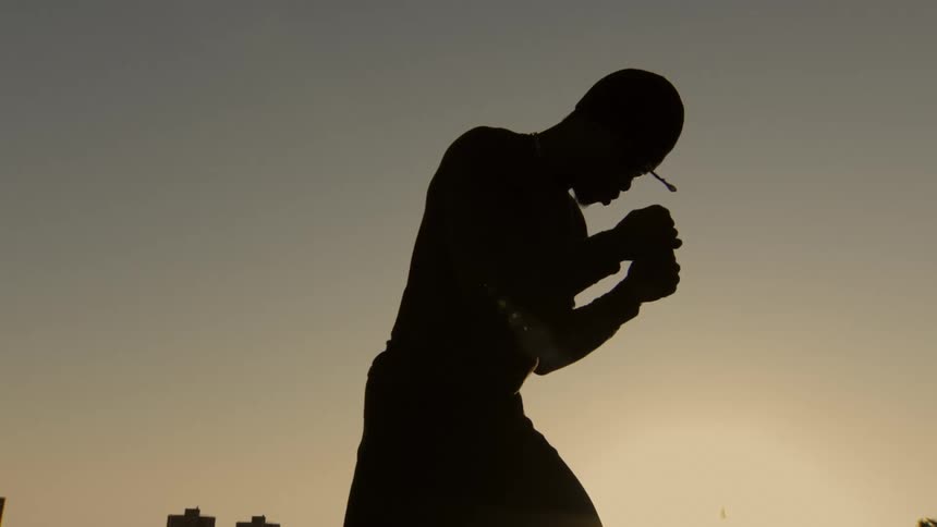 Cinemagraph of the silhouette of a man in a boxer's stance against the sunrise