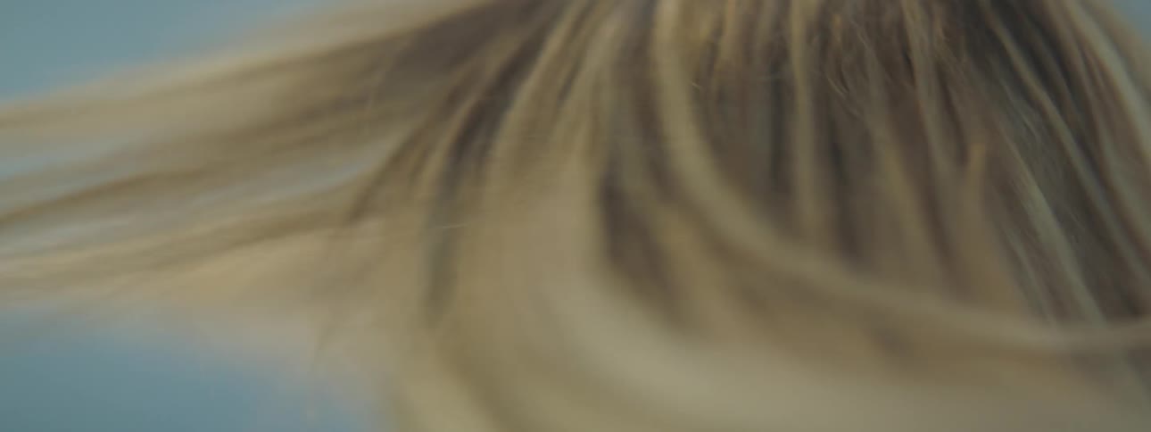 A woman shakes her hair back and forth