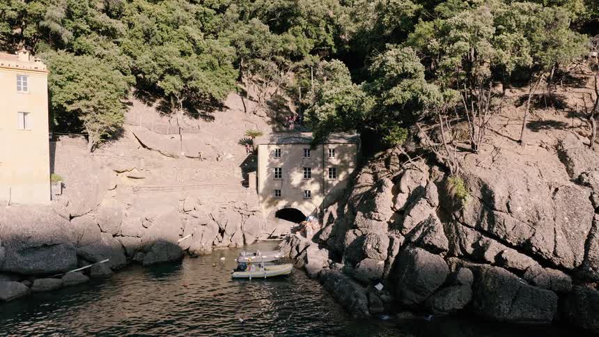 Aerial shot of the historic Abbey of San Fruttuoso with small boats moored in its secluded cove on the Italian Riviera