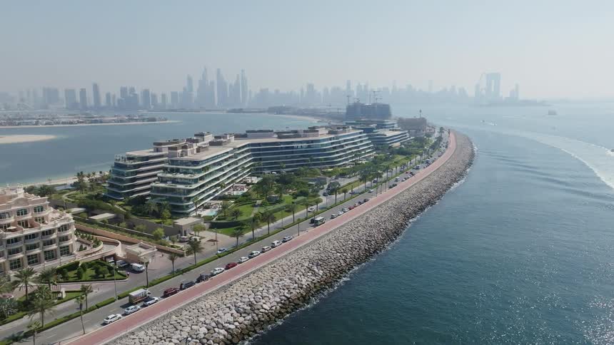 A static aerial view of the W Dubai - The Palm hotel with the city skyline in the background