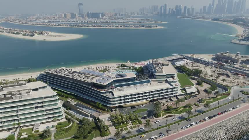 Static aerial view of the W Dubai hotel on the Palm Jumeirah with the Dubai Marina skyline in the background