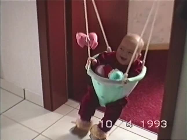 Adorable baby has a great time laughing and bouncing in a door bouncer in this nostalgic 1990s home video