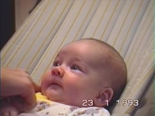 A vintage close-up from 1993 shows a baby's wide range of expressions as they laugh, smile, and get fussy while lying in a bouncer