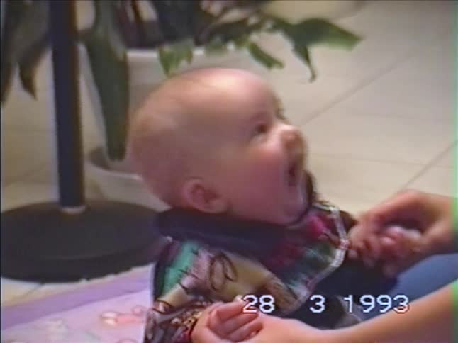 Vintage 1993 home video footage of a smiling and laughing baby held by an adult's hands
