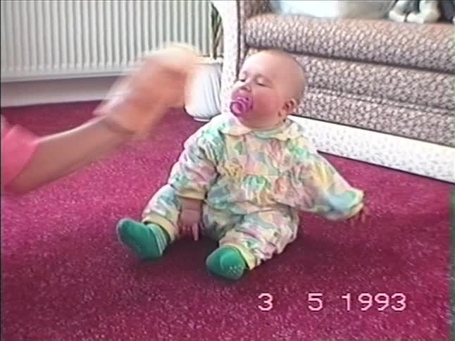 Vintage 1993 home video shows a mother playfully interacting with her baby using a horse hand puppet