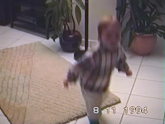 Vintage VHS footage from 1994 shows an energetic toddler happily dancing and jumping around at home