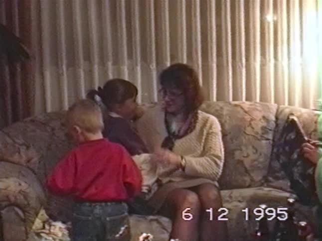 Authentic 1995 home video shows a family with young children receiving gifts from Santa Claus in their living room
