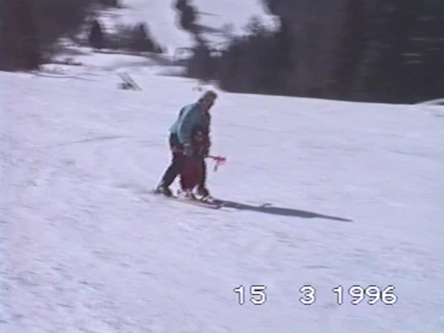 Vintage home movie from 1996 shows an adult patiently guiding a small child down a snowy ski slope