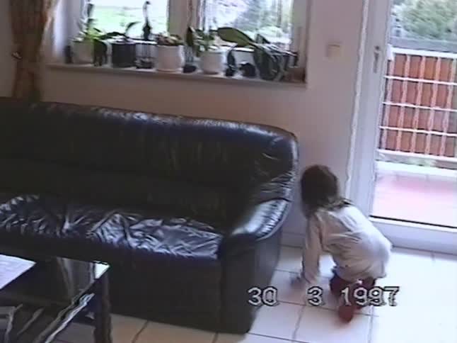 Authentic 1997 home movie footage of a little girl playing on the tiled floor in her living room