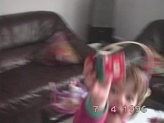 A vintage home video from 1996 shows an adorable toddler in pink pajamas excitedly showing off her new Easter gift to the camera