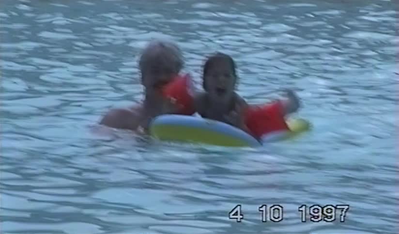 Vintage 1997 footage shows a father happily playing with his daughter in a swimming pool