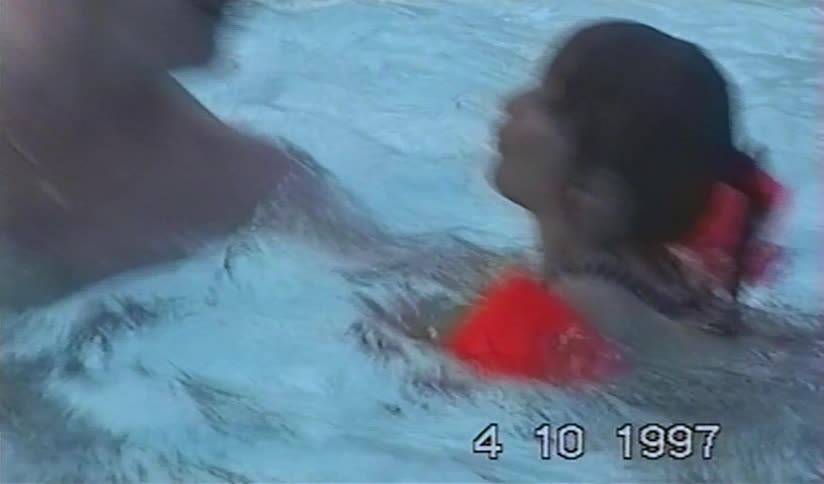 A father lovingly hugs his daughter after she falls into the swimming pool in this nostalgic home movie from 1997