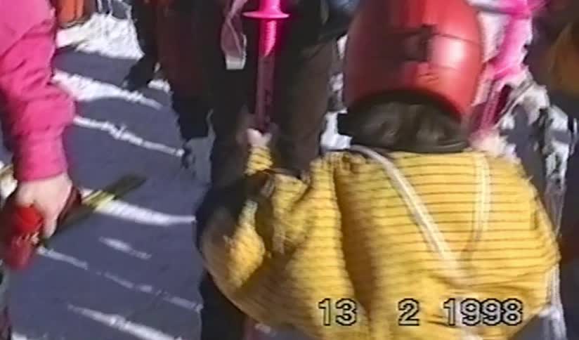 Vintage 1998 footage of a little skier with a red helmet and sunglasses posing for the camera on a snowy mountain