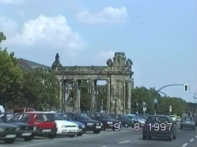 Archival 1997 footage from a car driving on a busy street toward the Charlottenburg Gate in Berlin, Germany