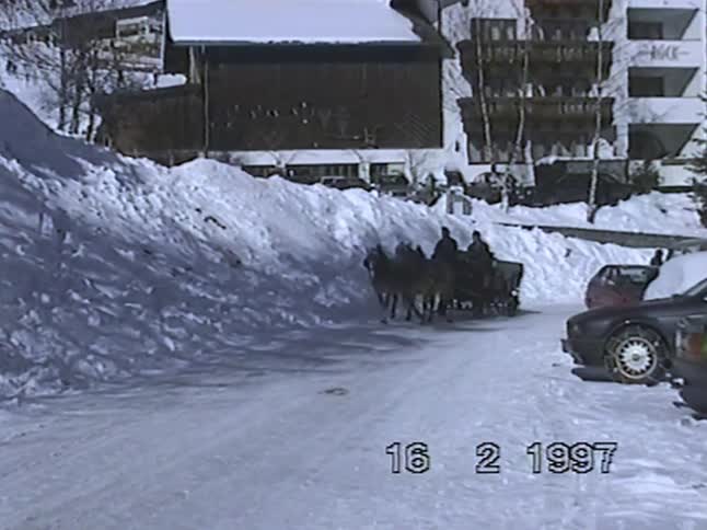 Archival footage from 1997 captures a horse-drawn carriage traveling down a snow-covered road in a winter resort town