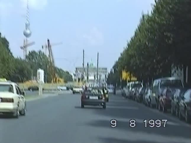Vintage 1997 VHS footage of traffic on a Berlin street with the Brandenburg Gate and TV Tower in the background