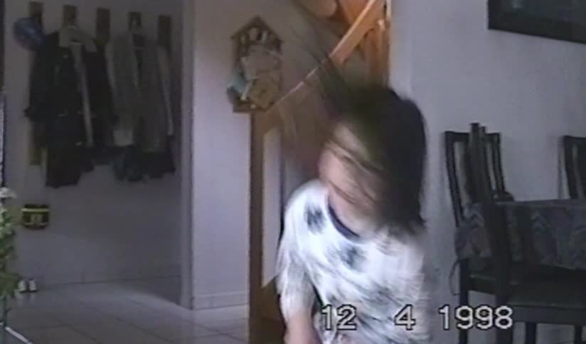 A happy young girl in her pajamas jumps up and down excitedly in her home in this authentic 1998 home video