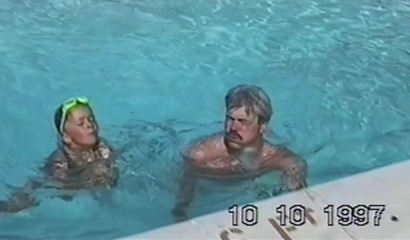 A father and daughter enjoy a leisurely swim and chat in a pool in this nostalgic home video from 1997