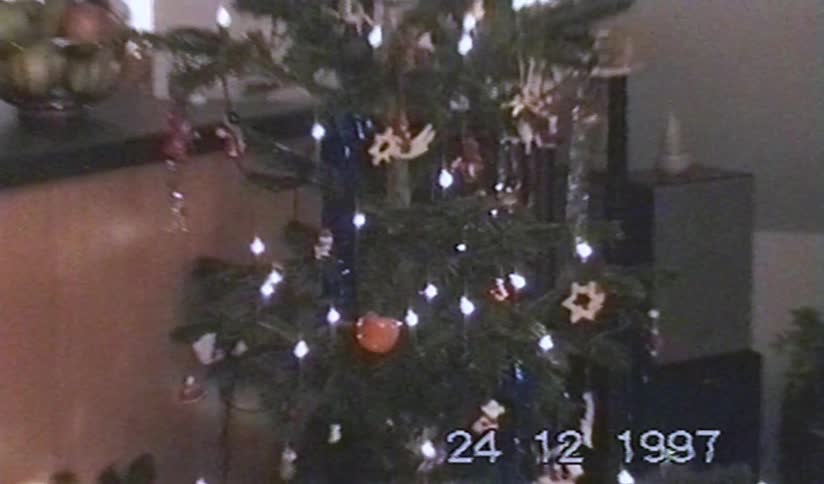 Vintage 1997 VHS footage zooms out from a decorated Christmas tree with bright lights in a cozy home