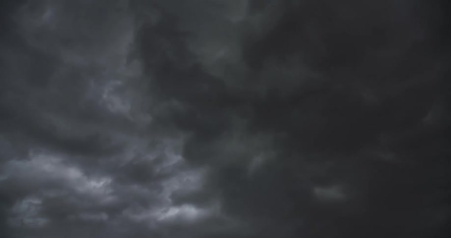 A dramatic display of lightning strikes illuminates the dark, stormy clouds