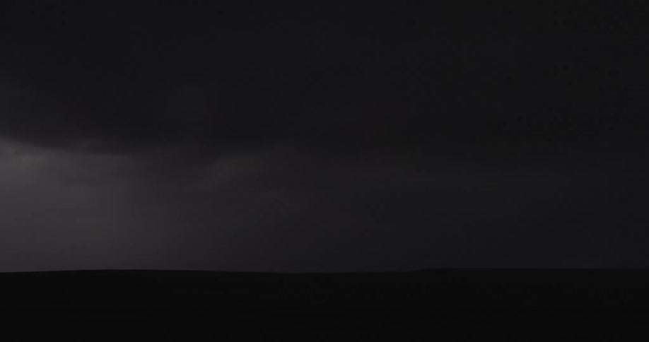 Powerful lightning bolts repeatedly strike down from a dark, stormy sky over a silhouetted plain