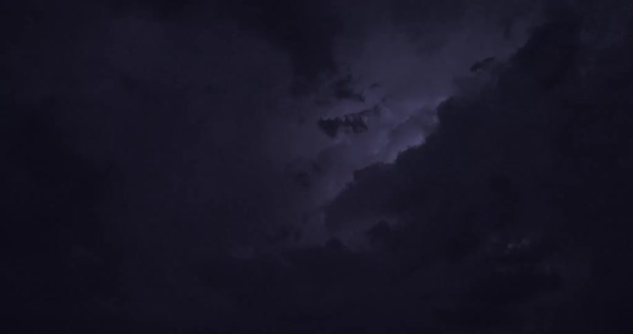 Dramatic flashes of lightning illuminate the dark, turbulent clouds of a powerful nighttime thunderstorm