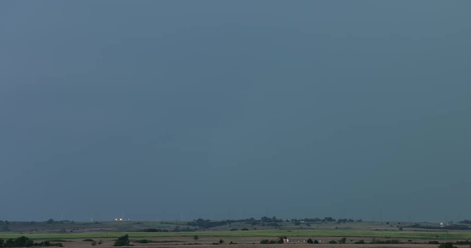 A dramatic slow-motion compilation shows multiple powerful lightning strikes illuminating the night sky over a rural landscape
