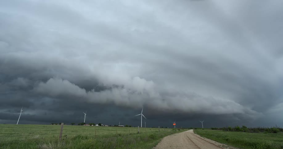 A menacing supercell storm cloud moves across a rural landscape dotted with wind turbines in this dramatic time-lapse