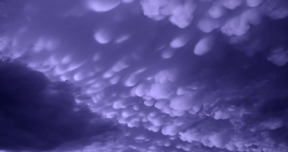 A dramatic, purple-hued sky filled with ominous mammatus clouds