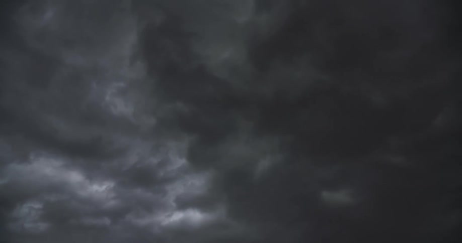 Lightning flashes through a sky filled with dark, churning storm clouds
