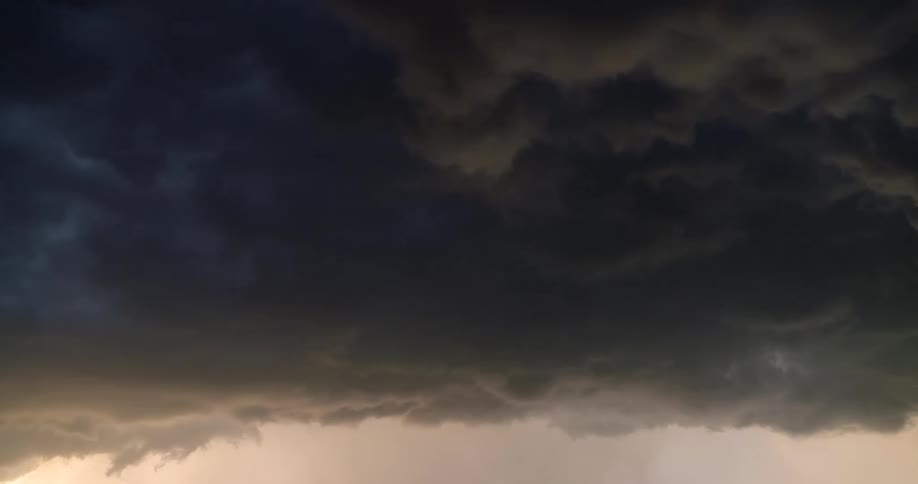 Ominous dark storm clouds churn and swirl across the sky in a dramatic time-lapse
