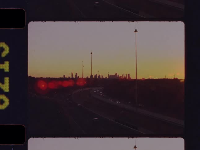 A nostalgic, film-strip style video montage of a young woman and a city skyline with highway traffic at sunset