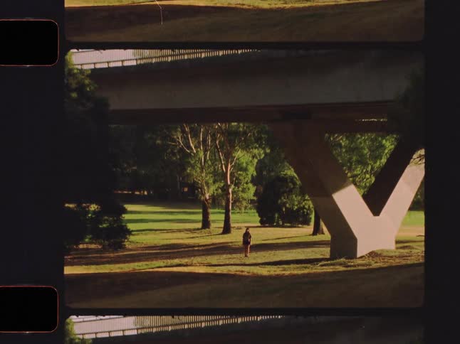 Super 8mm style film captures nostalgic scenes of a lonely young woman at sunset and standing in a park