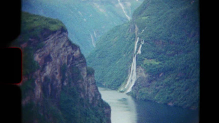 Vintage 8mm footage captures the majestic Geiranger Fjord in Norway, with waterfalls and snow-capped mountains