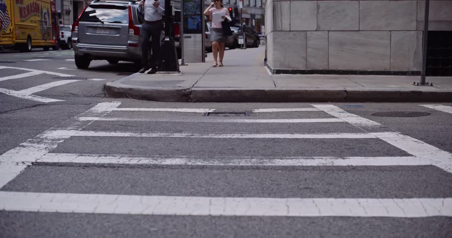 A street-level perspective captures the flow of pedestrians and traffic at a city crosswalk