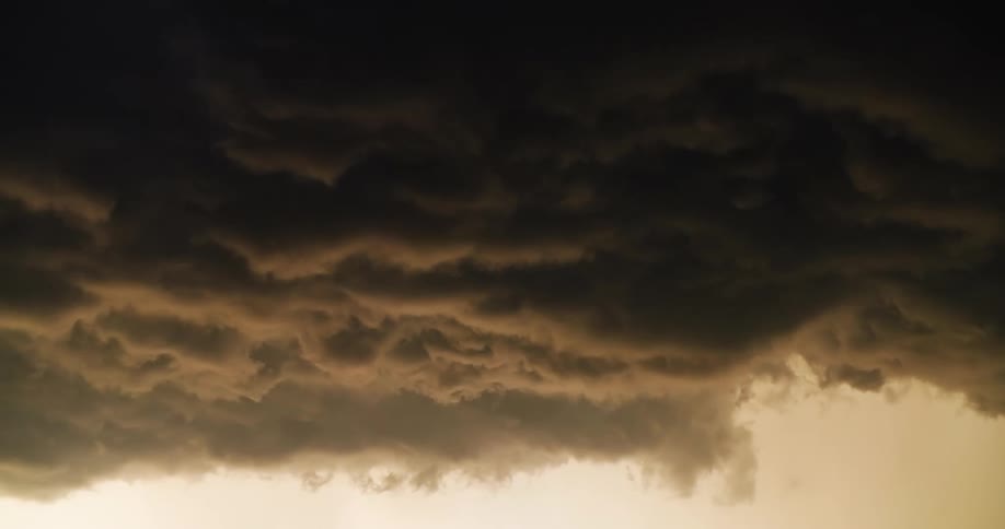 Dark, ominous, and turbulent storm clouds slowly churn in the sky