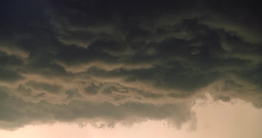 A static shot of the turbulent and ominous underbelly of a heavy, dark storm cloud system