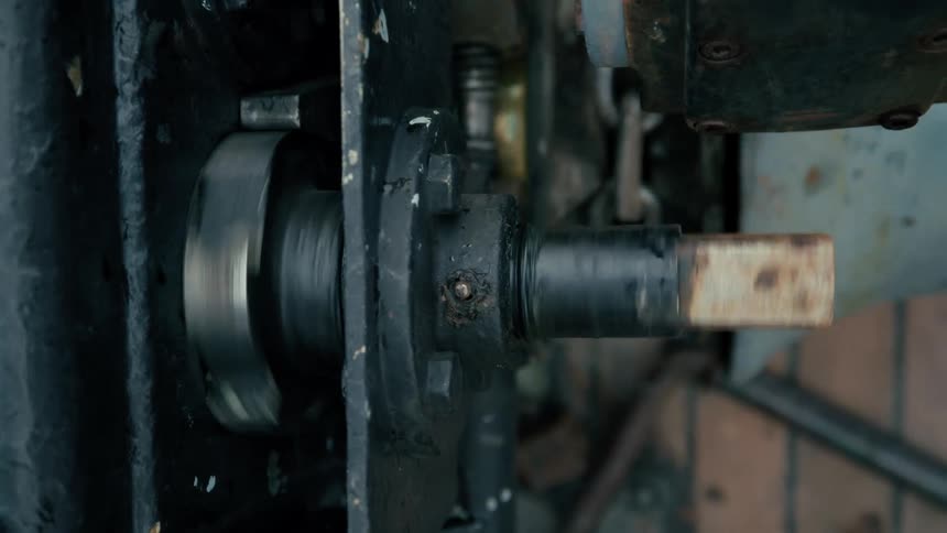 A close-up view of a rotating metal shaft on a piece of industrial machinery