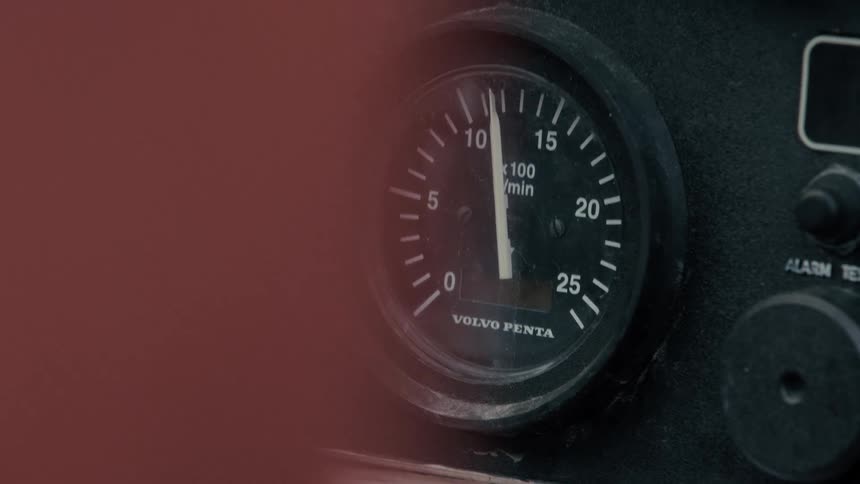 A close-up of a dusty Volvo Penta tachometer on an idling engine, with the needle fluctuating slightly