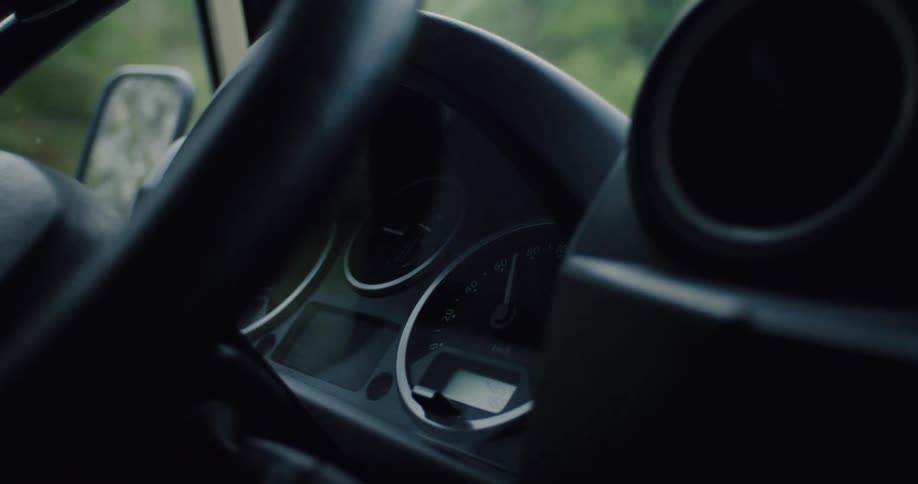Close-up of a car's speedometer and dashboard from the interior while driving on a journey
