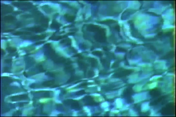 A calming close-up shot of gently rippling water with light reflecting off the surface, creating an abstract pattern