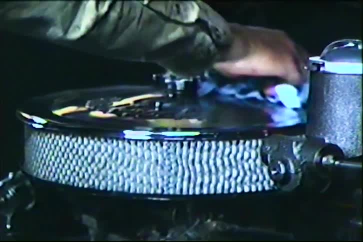 A mechanic carefully polishes the chrome air cleaner on a classic car engine in a garage