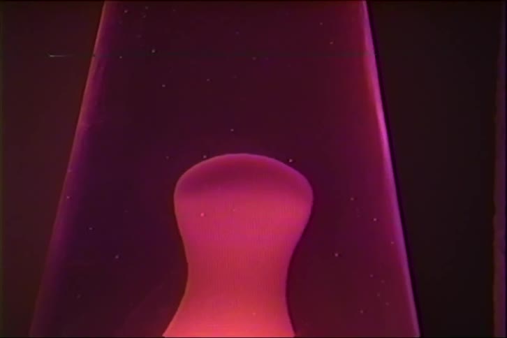 A mesmerizing close-up of a pink lava lamp shows the wax slowly rising, separating, and falling in a classic retro display