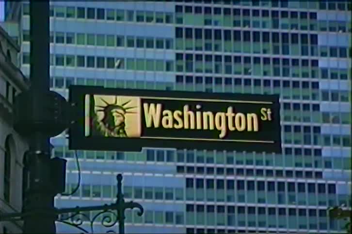 Vintage archival footage shows the Washington Street sign in New York City with a modern building behind it