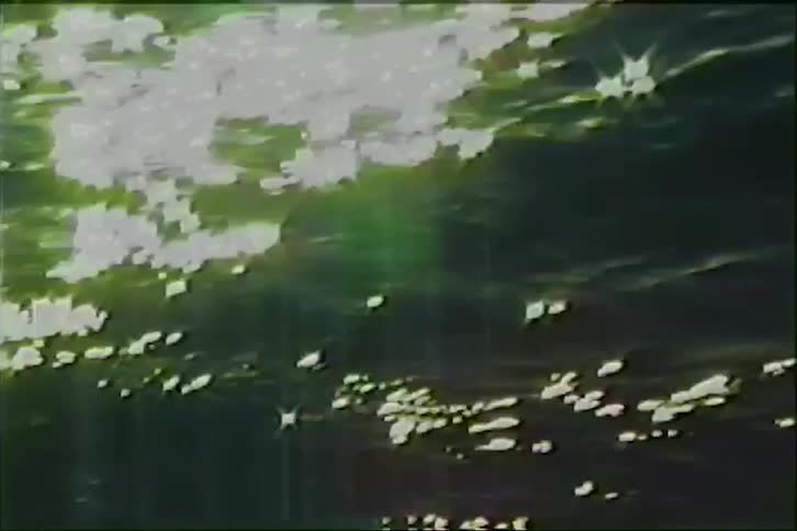 Vintage footage captures the sun's brilliant reflection sparkling and shimmering across the surface of deep blue ocean waves