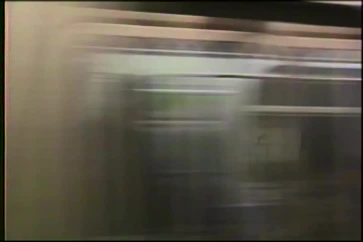 A fast-moving subway train speeds by the station in this vintage close-up shot