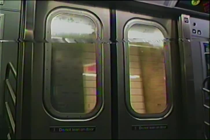 Vintage VHS footage shows an interior view of a New York City subway train's doors closing and leaving the station