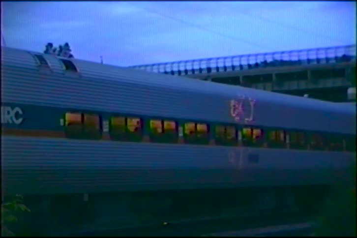 A MARC commuter train moves slowly along the tracks at dusk in this vintage VHS footage