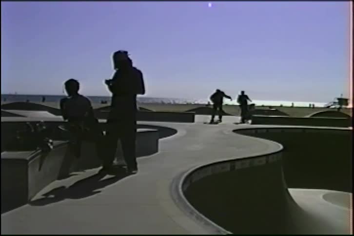Vintage VHS footage shows silhouetted skaters at the iconic Venice Beach skatepark in the 1990s